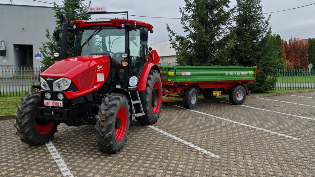 Traktor autoškoly s prívesom v areáli školy