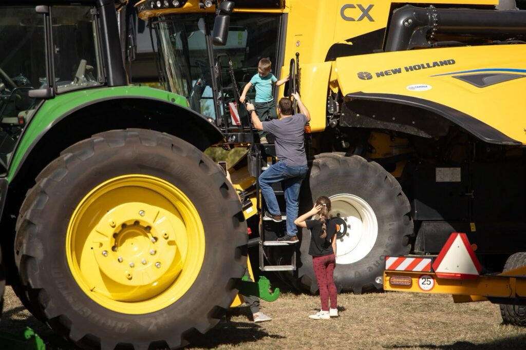 Deti si prezerajú kombajn a traktor na výstave poľnohospodárskych strojov